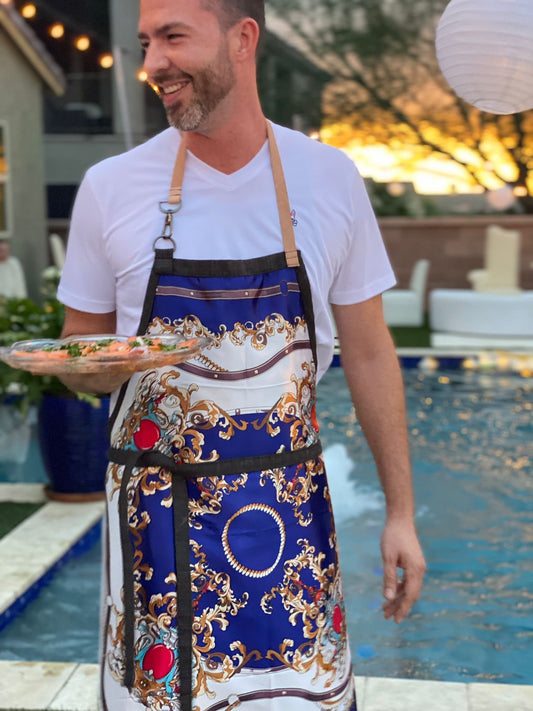Joyful man serving food by his pool and wearing lux double sided Royalty apron with leather strap and front pocket