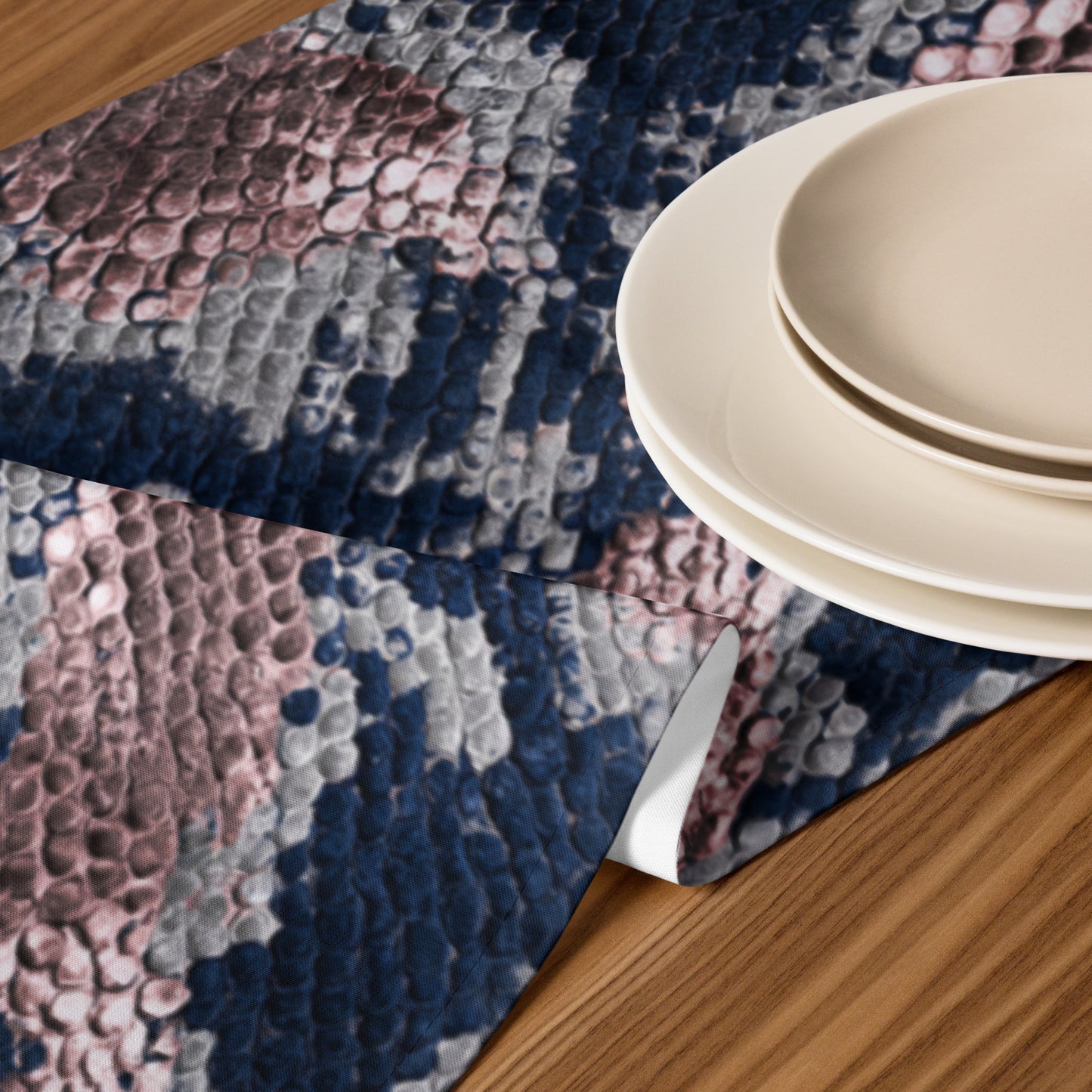 Closeup of serpent table runner with sophisticated python print in navy and blush