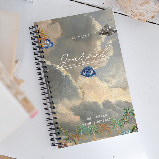My Daily Journal spiral notebook featuring mystical all-seeing eye design with dreamy clouds, gold accents, and palm trees, with reminder text to Be Gentle With Yourself'