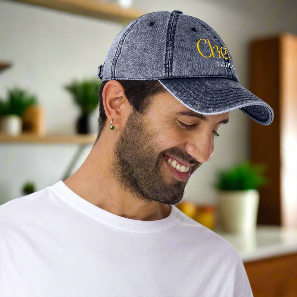 Man wearing the Chef's Table embroidered navy vintage cap with cotton twill and brass buckle
