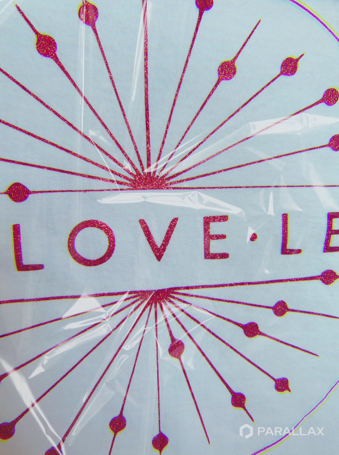 Animated close-up of red sparkle logo through clear protective wrapping, showing glitter detail 