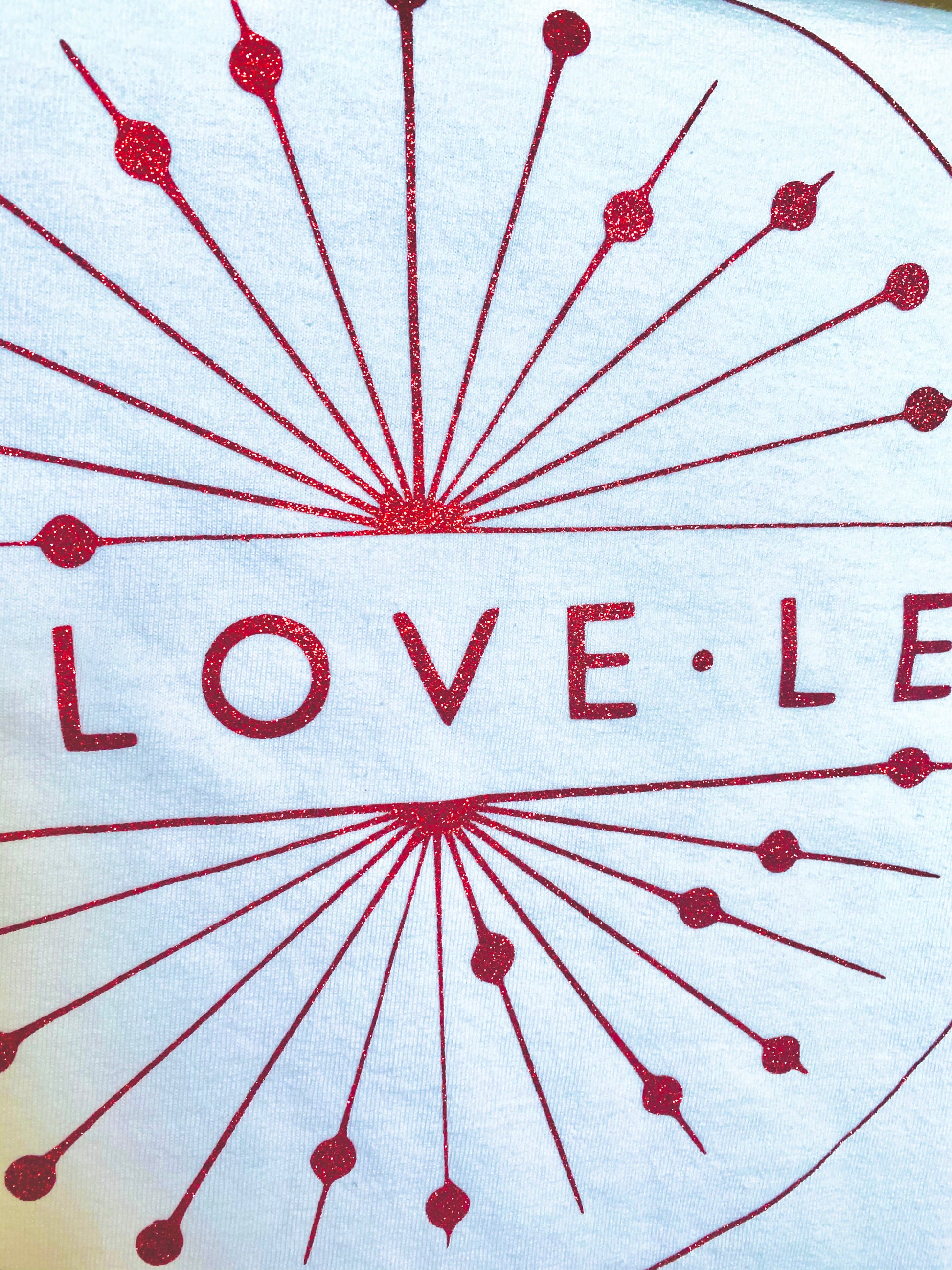 Red decorative glitter design with 'LOVE' text on a white t-shirt