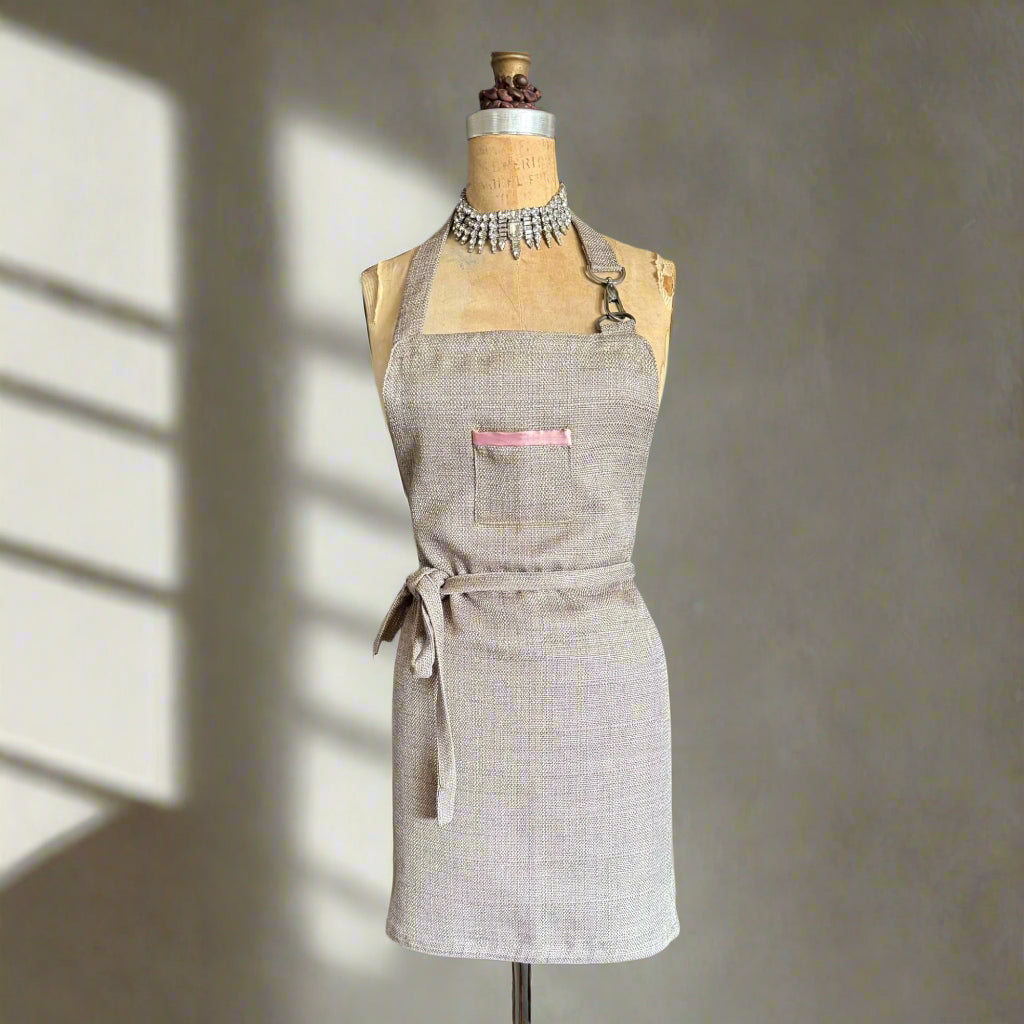 Grey apron on a mannequin against a gray  sunlit background